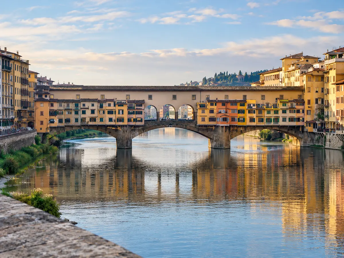Il Ponte Vecchio sull'Arno all'ora dorata, con il lungo piano superiore coperto sopra le botteghe